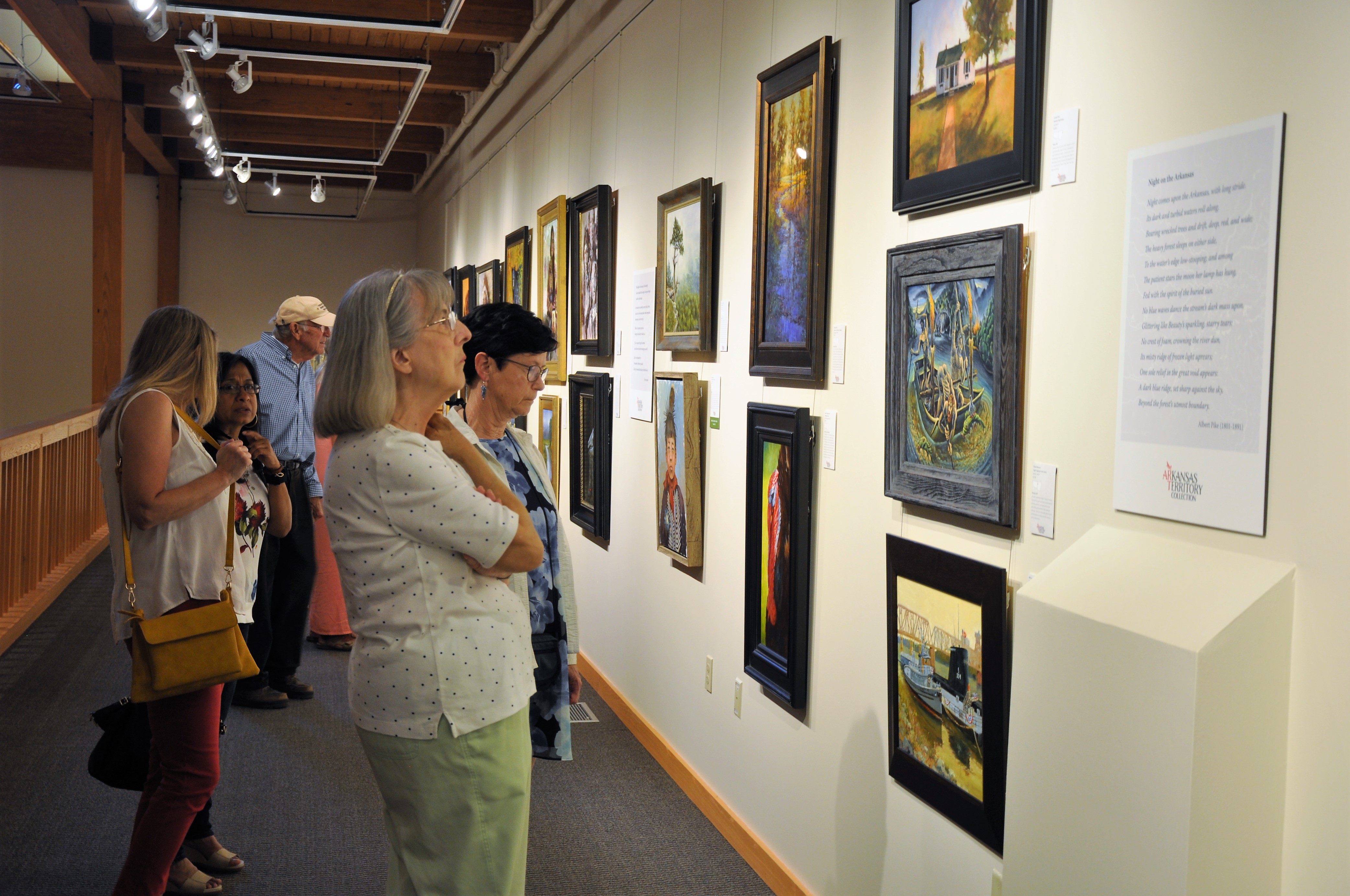 people in art gallery observing wall art