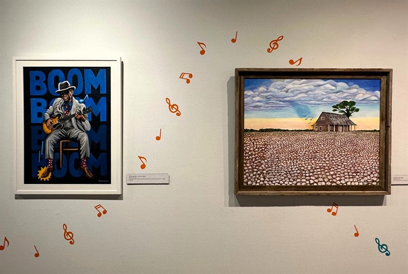 John Goodwin Exhibit Photo Fifteen Art on a gallery wall with music note stickers floating in a line through them.