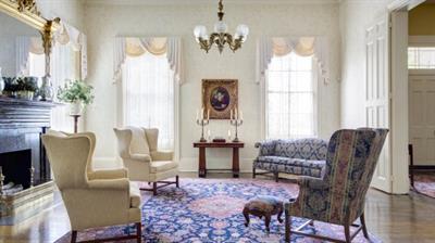 sitting room with couch, three chairs, patterned rug, fireplace and curtains